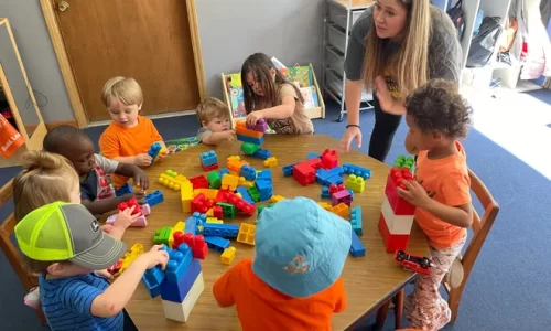 Piggytoes owner/operator Trish Watts encourages children to play with block at the day care's new location in Grovetown