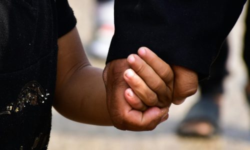Adult holding a child's hand