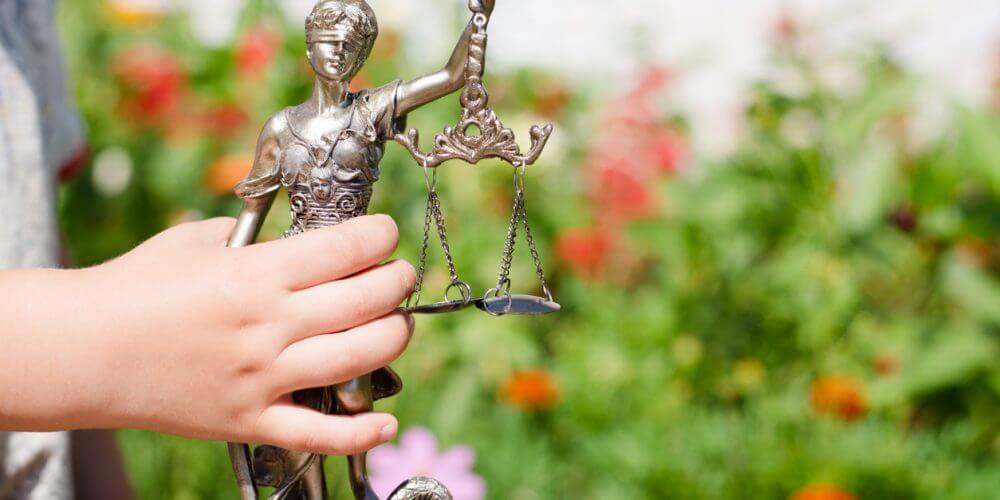 Kid's hand holding sculpture of Themis