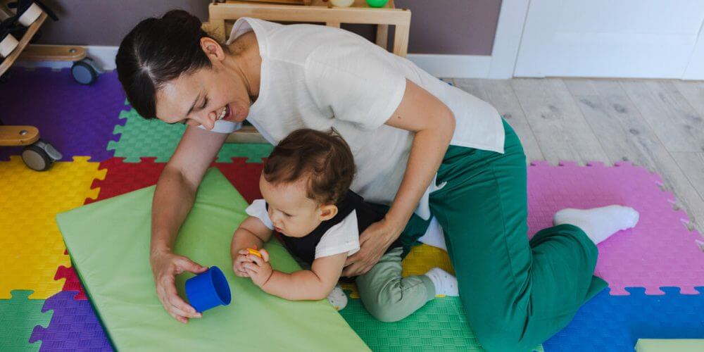 Little boy with musculoskeletal disorders in rehab corset engages in a physical rehabilitation session aided by a therapist in therapy space